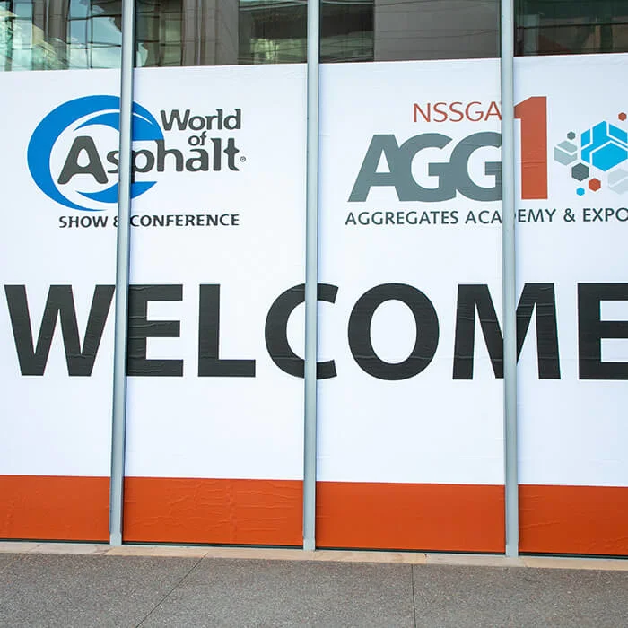 Welcome sign on window with World of Asphalt and AGG1 logo