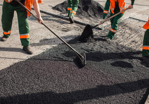Builder during Asphalting road works level raw material before the operation of the machine