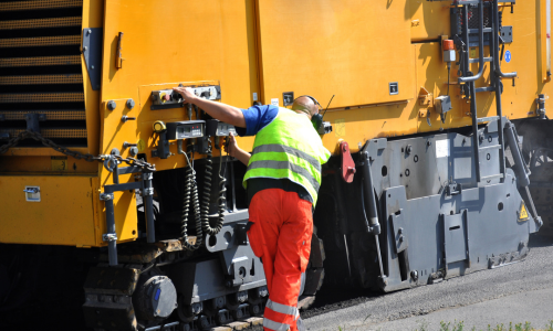 construction worker fixing a machine