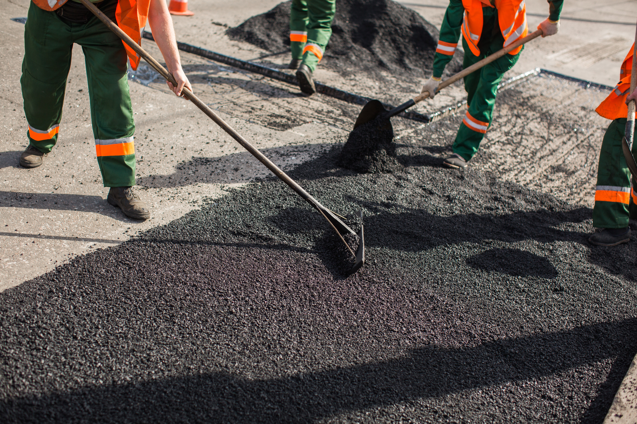 Builder during Asphalting road works level raw material before the operation of the machine